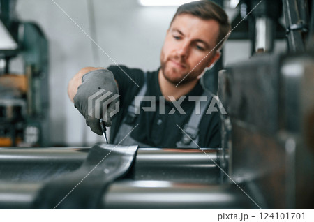Clean parts. Man in uniform is in workstation developing details of agriculture technique 124101701