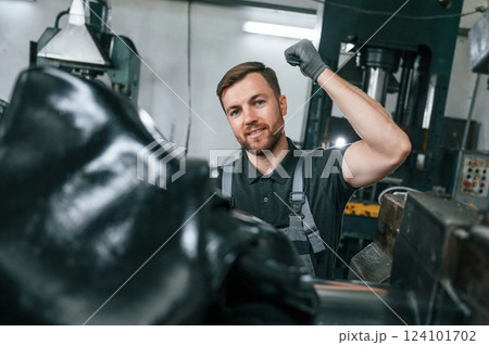 Clean parts. Man in uniform is in workstation developing details of agriculture technique 124101702
