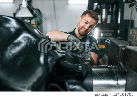 Clean parts. Man in uniform is in workstation developing details of agriculture technique 124101703
