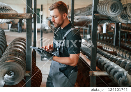 Checking details. Man in uniform is in workstation developing details of agriculture technique 124101745
