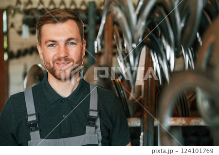 Portrait of man in uniform that is in workstation developing details of agriculture technique Portrait of man in uniform that is in workstation developing details of agriculture technique 124101769