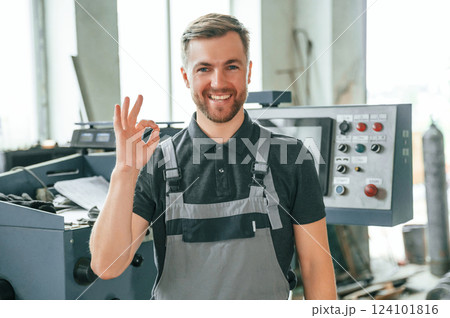 Standing near operate device. Man in uniform is in workstation developing details of agriculture technique 124101816