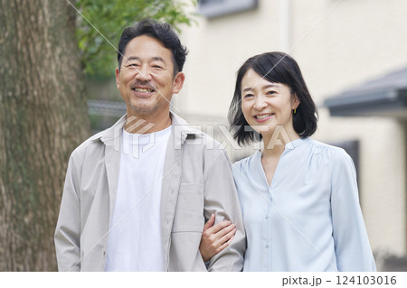 腕を組んで散歩する中年の夫婦　屋外 124103016