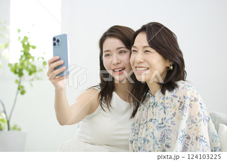 スマホを一緒に見るおしゃれな母と娘 124103225