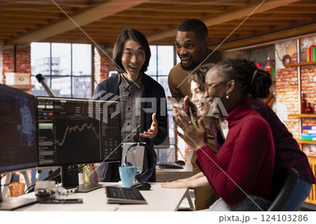 Cheerful multiethnic startup team celebrating high valuation on stock exchange, raising money. Tech business entrepreneurs securing angel investments, becoming unicorn company 124103286