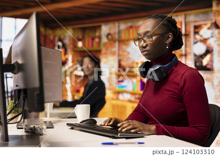 Silicon Valley venture engineer solving tasks with AI LLM chatbot answering prompts using predictive technology. African american startup IT worker using computer to interact with generative model app 124103310