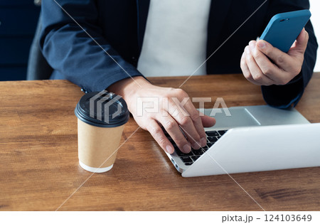 パソコンとスマホを操作する男性 パソコンとスマホを操作する男性 124103649