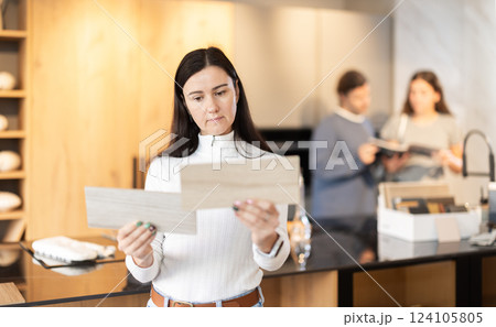 Adult woman choosing wood for floor in furniture salon 124105805