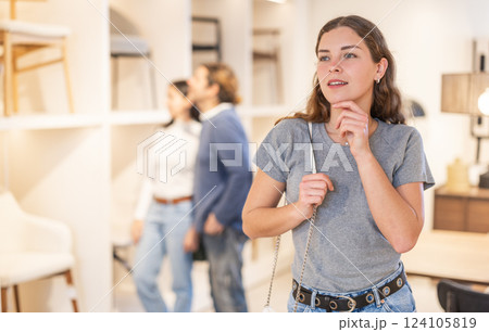 Young woman choosing decoration in furniture salon 124105819