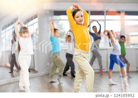 Happy smiling preteen boys and girls practicing dance, with female trainer in dance hall 124105952