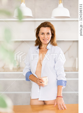 Nude adult woman in shirt posing in kitchen 124106531