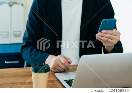 パソコンとスマホを操作する男性 124106589