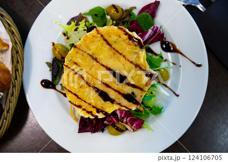 Scallop baked with cheese in seashells, served with lettuce 124106705