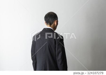 悩み、落ち込み、不安をイメージする中高年男性のスーツの後ろ姿 124107279