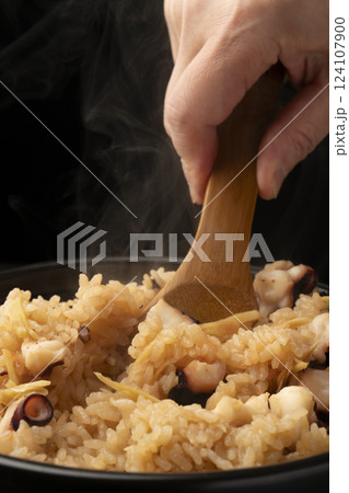 炊きたてで湯気の立った蛸の炊き込みご飯をしゃもじで茶碗に盛り付ける 炊きたてで湯気の立った蛸の炊き込みご飯をしゃもじで茶碗に盛り付ける 124107900