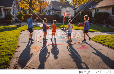 Group of children playing basketball in a driveway. The children are wearing shorts and shirts, and they are holding basketballs Group of children playing basketball in a driveway. The children are wearing shorts and shirts, and they are holding basketballs 124108981