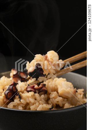 炊きたてで湯気の立った蛸の炊き込みご飯を箸で持ち上げる 124109678