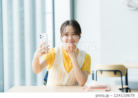 カフェでスマホを見る学生 124110679