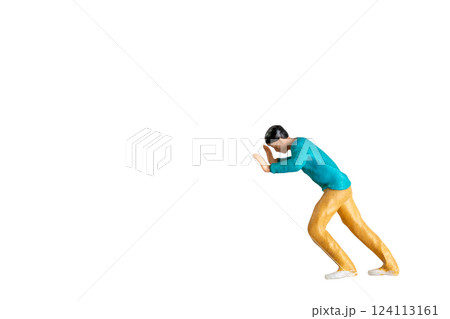 Miniature Figurine Pushing Against Invisible Force isolated on white background with clipping path 124113161