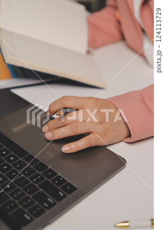 Cropped image of professional businesswoman working at her office via laptop, young female manager using portable computer device while sitting at modern loft, flare light, work process concept Cropped image of professional businesswoman working at her office via laptop, young female manager using portable computer device while sitting at modern loft, flare light, work process concept 124113729