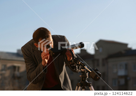 Astronomer examines the sun using a specialized telescope on rooftop 124114622