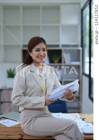 professional businesswoman planning and analyzing marketing charts and financial documents with a laptop and calculator papers on the desk professional businesswoman planning and analyzing marketing charts and financial documents with a laptop and calculator papers on the desk 124117652