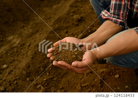 Farmer inspecting soil texture and composition, preparing for planting 124118433