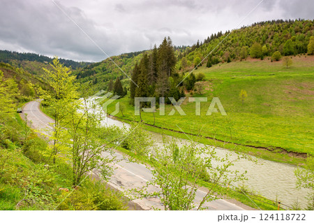 mountain landscape with road along river. beautiful scenery in spring. nature background for travel. green outdoor with forest on the hill. natural environment for adventure in countryside valley 124118722