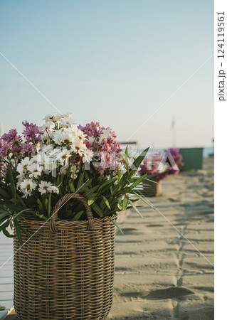 Basket of Flowers on Sandy Beach in Tranquil Setting Basket of Flowers on Sandy Beach in Tranquil Setting 124119561