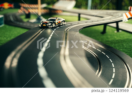 Miniature Race Car on Toy Track with Curved Road 124119569