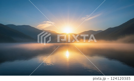 Sunrise Over Tranquil Lake Surrounded by Misty Mountains 124120385