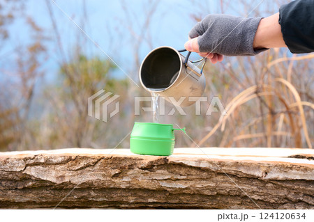 山でカップにお湯を注ぐところ 124120634