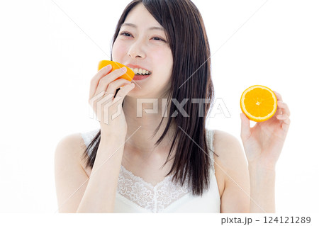 フルーツを食べる女性　オレンジ 124121289