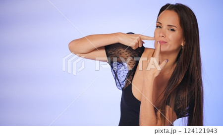 Beauty blogger pointing at facial skin with a playful expression Beauty blogger pointing at facial skin with a playful expression 124121943