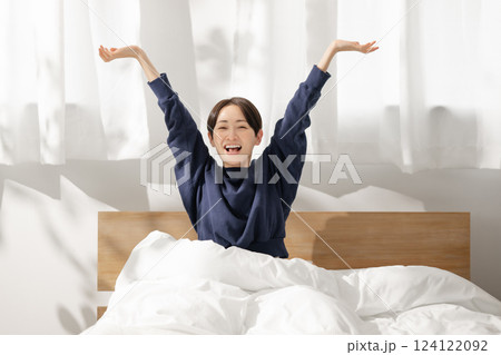 ベッドで伸びをする女性 ベッドで伸びをする女性 124122092