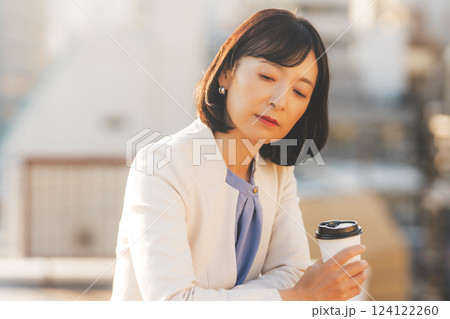 壁にぶつかり一人考え事をするミドルキャリアウーマン 壁にぶつかり一人考え事をするミドルキャリアウーマン 124122260