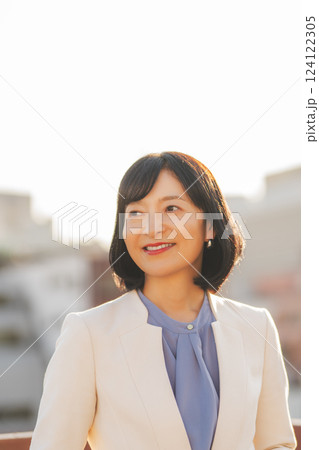 屋上で一休みするミドルキャリアウーマン 屋上で一休みするミドルキャリアウーマン 124122305