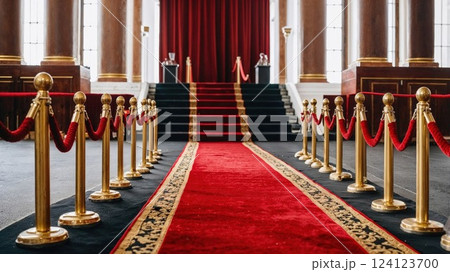 A luxurious red carpet leading up to a grand staircase, framed by golden stanchions and velvet ropes. The elegant setting evokes a sense of glamour, perfect for awards, events, and VIP occasions 124123700