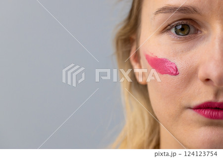 Capturing the Bold Expression of Artistic Makeup with a Close-Up of a Woman's Face Showcasing Vibrant Pink Lipstick and Brush Strokes on Her Cheek Capturing the Bold Expression of Artistic Makeup with a Close-Up of a Woman's Face Showcasing Vibrant Pink Lipstick and Brush Strokes on Her Cheek 124123754