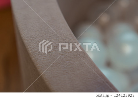 Close-Up View of Soft Textured Fabric Container Edge with Blurred Background of Translucent Objects 124123925