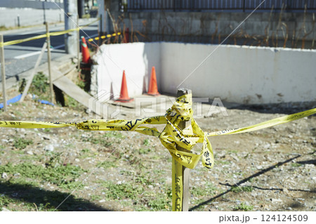 立ち入り禁止の黄色いテープ 住宅街の中途半端な空き地に貼られた立入禁止テープ	 124124509