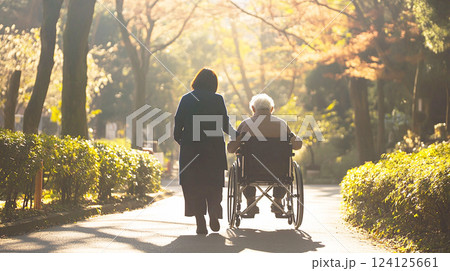 車椅子の高齢者を介助する女性 124125661