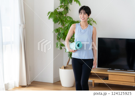 リビングでヨガをする女性 リビングでヨガをする女性 124125925