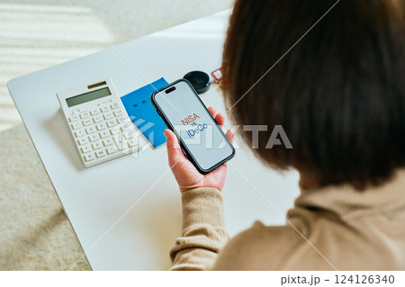 スマホを操作するシニア女性　NISAvsiDeCo 124126340