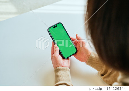 スマホを操作するシニア女性 グリーンバック スマホを操作するシニア女性 グリーンバック 124126344