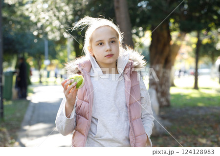 Cute child girl walking in city park outdoors. Healthy playful kid portrait Cute child girl walking in city park outdoors. Healthy playful kid portrait 124128983