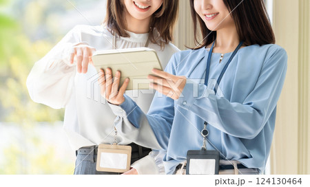 タブレットを見て話す2人の女性・ビジネスウーマン タブレットを見て話す2人の女性・ビジネスウーマン 124130464