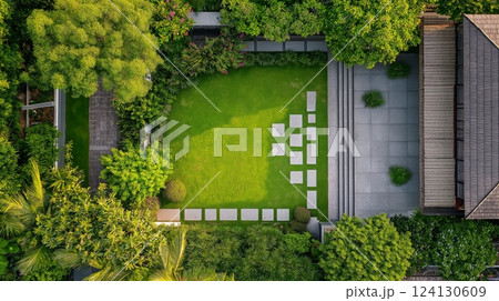 Beautiful tranquil garden with wooden deck, stone paths, and lush greenery 124130609