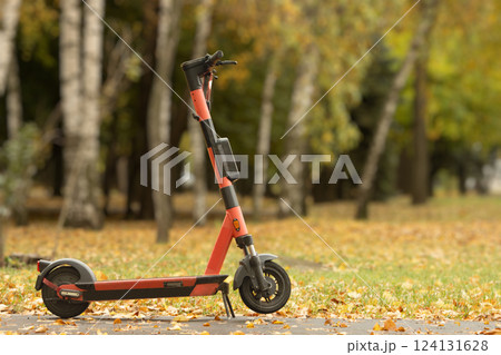 Electric scooter against the backdrop of an autumn park in warm tones 124131628
