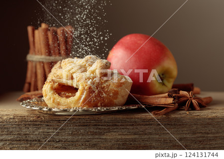 Viennese strudel with apple and cinnamon on old wooden table. Viennese strudel with apple and cinnamon on old wooden table. 124131744